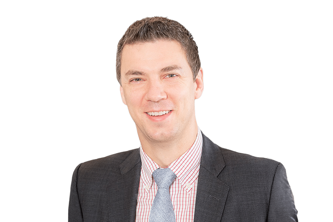Professional head-and-shoulders portrait of a smiling man in a dark suit and light tie.